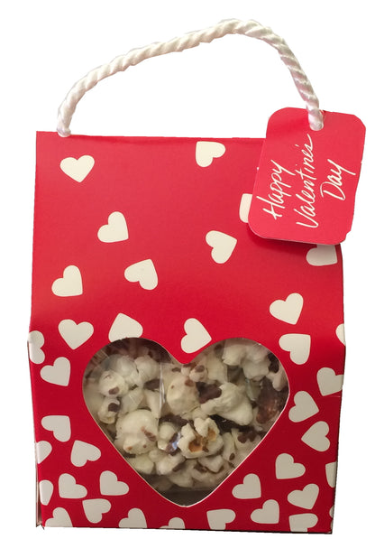 Red gift bag with heart patterns and a tag reading 'Happy Valentine's Day', containing popcorn.