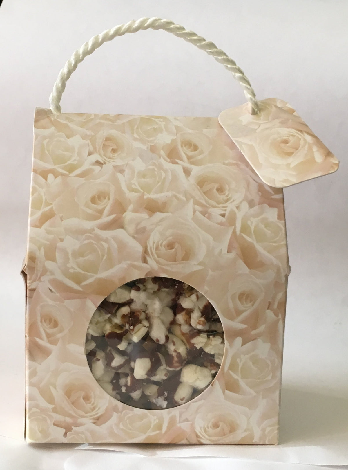 Gift box with rose pattern and window to reveal contents on a white background