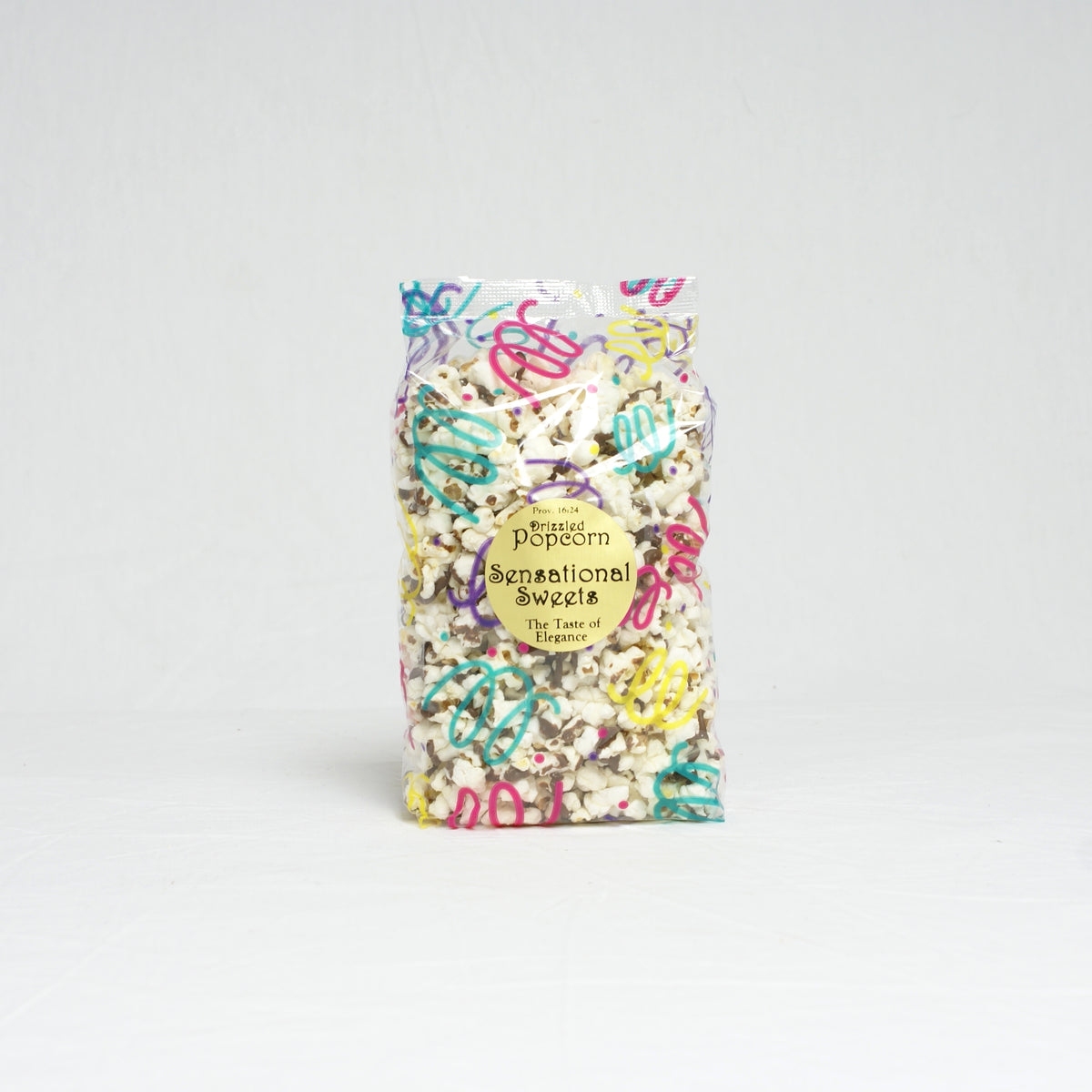 Packaged popcorn with colorful sprinkles on a light gray background