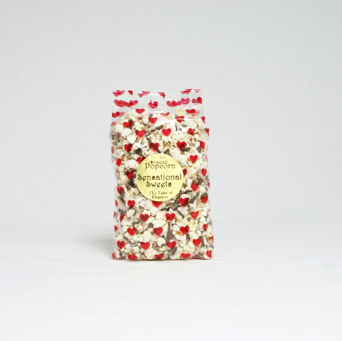 Bag of popcorn with red heart patterns on a light gray background